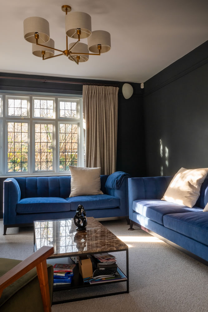 Discreet corner-mounted speakers and automated curtains in a modern living room, part of the AVINU Northmoor Road smart home project