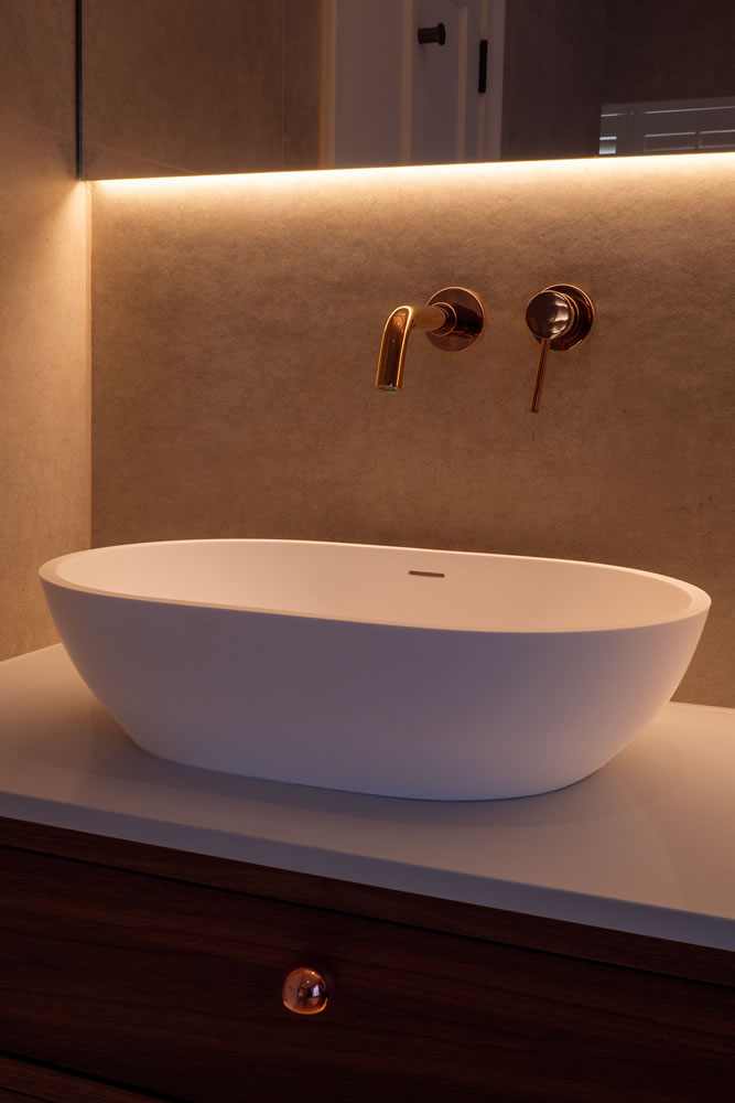 Automated discreet lighting scene highlighting high-end sink and tap hardware in a Northmoor residential smart home installation