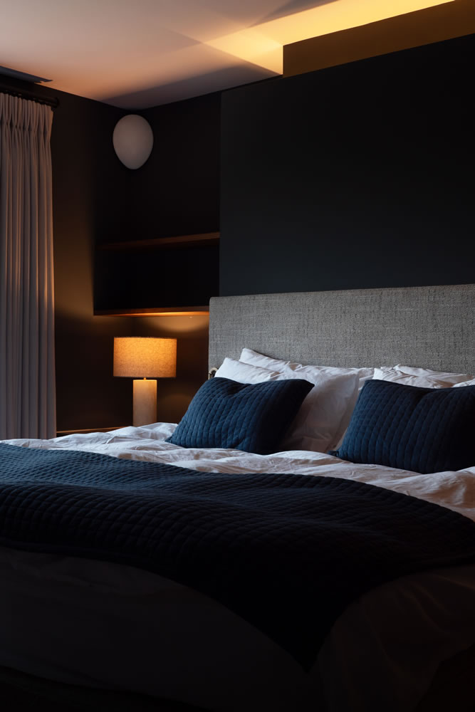 Modern luxury bedroom in the AVINU Northmoor smart home project featuring integrated corner speakers and automated smart lighting