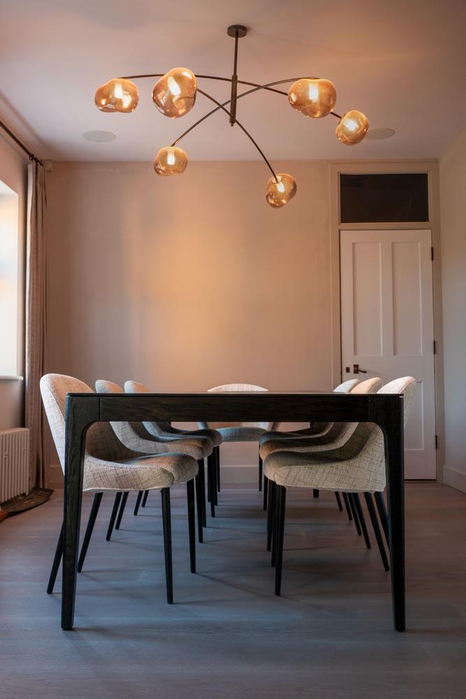Elegant dining room in the Northmoor Road smart home featuring warm integrated ceiling lighting and discreet flush-mounted speakers